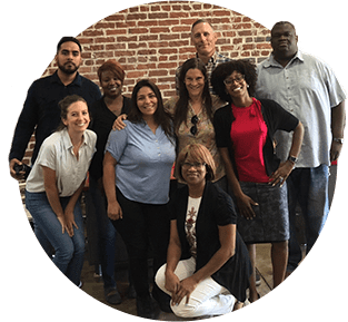 A group of people standing in front of a brick wall.