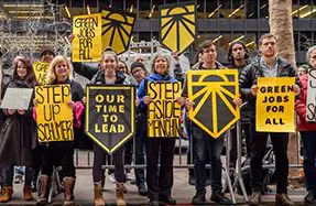 A group of people holding signs in front of a crowd.